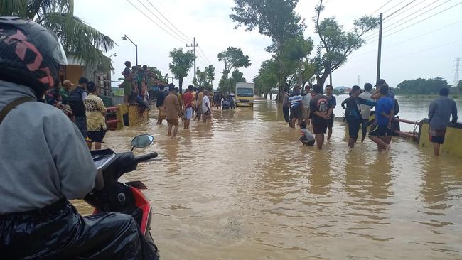 Pemotor terhenti melihat genangan air sepanjang jalan raya Jrengik Kab. Sampang