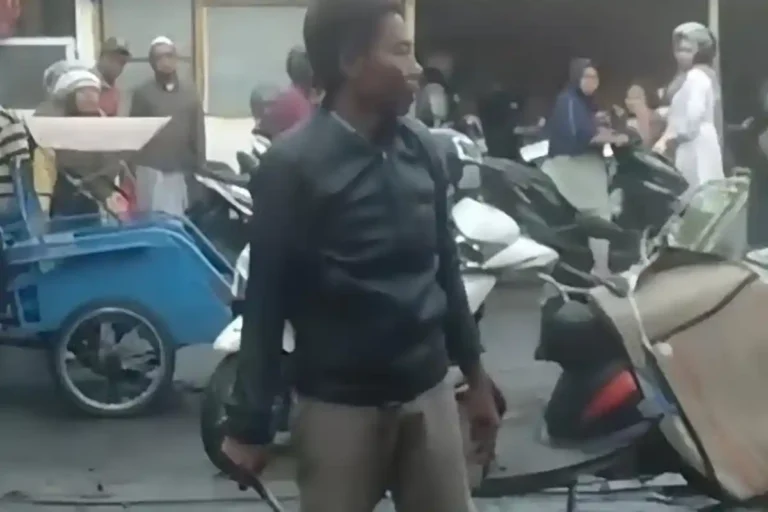 Seorang Pria diduga pelaku sedang memegang bilah clurit dalam peristiwa di Pasar Srimangunan, Kabupaten Sampang (09/11).